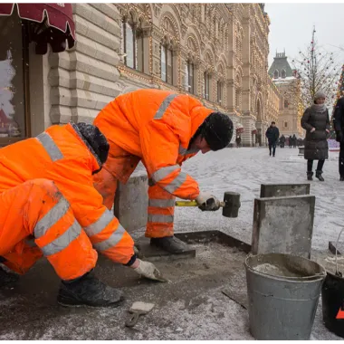 Рабочие ремонтируют тротуар 